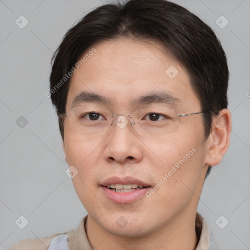 Joyful asian young-adult male with short  brown hair and brown eyes