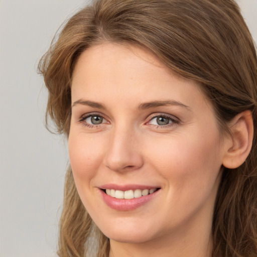 Joyful white young-adult female with long  brown hair and green eyes