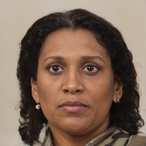 Joyful latino adult female with medium  brown hair and brown eyes
