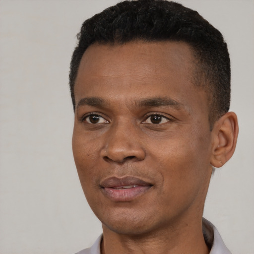 Joyful black young-adult male with short  black hair and brown eyes