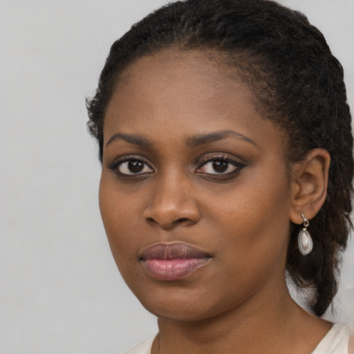Joyful black young-adult female with long  brown hair and brown eyes