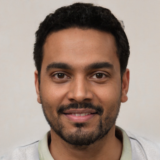 Joyful latino young-adult male with short  black hair and brown eyes