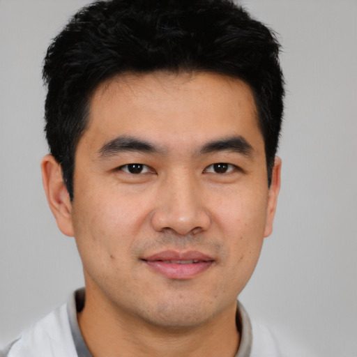 Joyful asian young-adult male with short  black hair and brown eyes
