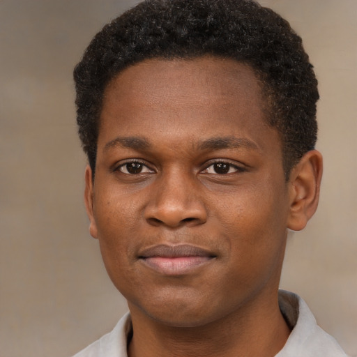 Joyful black young-adult male with short  brown hair and brown eyes