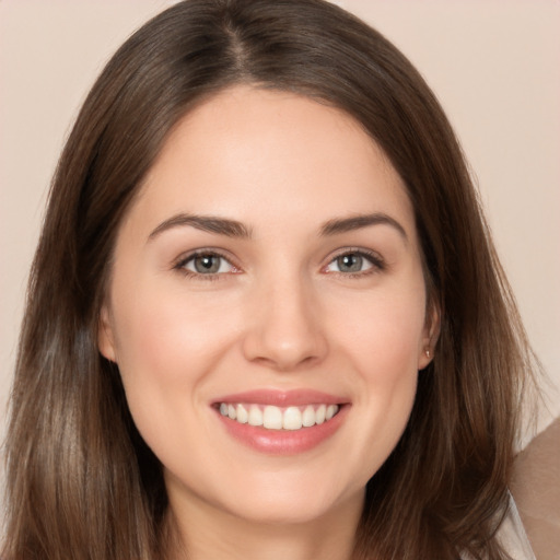 Joyful white young-adult female with long  brown hair and brown eyes