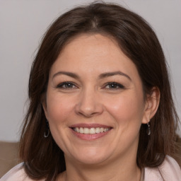 Joyful white adult female with medium  brown hair and brown eyes