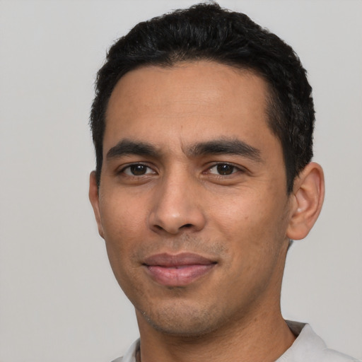 Joyful latino young-adult male with short  black hair and brown eyes