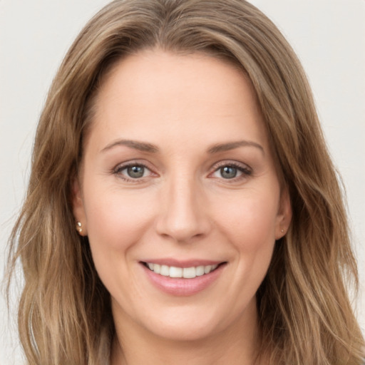 Joyful white young-adult female with long  brown hair and green eyes