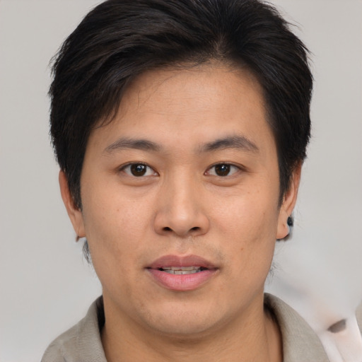 Joyful asian young-adult male with short  brown hair and brown eyes