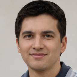 Joyful white young-adult male with short  black hair and brown eyes