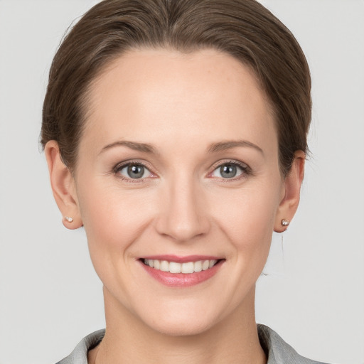 Joyful white young-adult female with short  brown hair and grey eyes