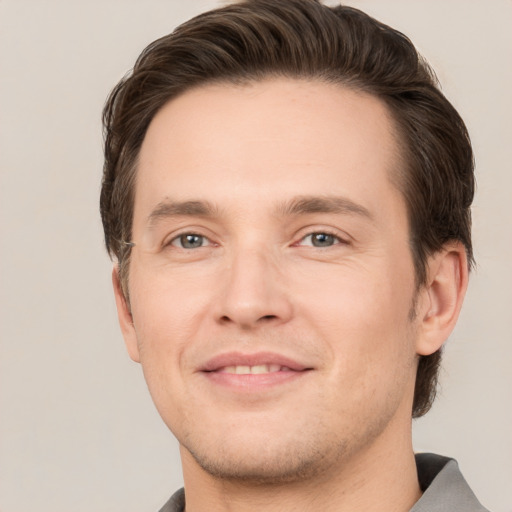 Joyful white young-adult male with short  brown hair and grey eyes