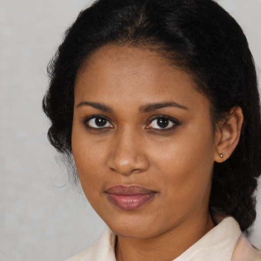 Joyful black adult female with medium  brown hair and brown eyes