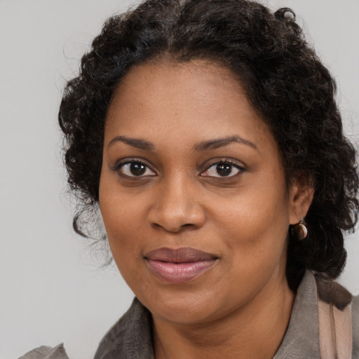 Joyful black adult female with long  brown hair and brown eyes