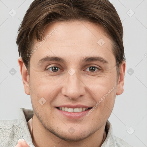 Joyful white young-adult male with short  brown hair and grey eyes