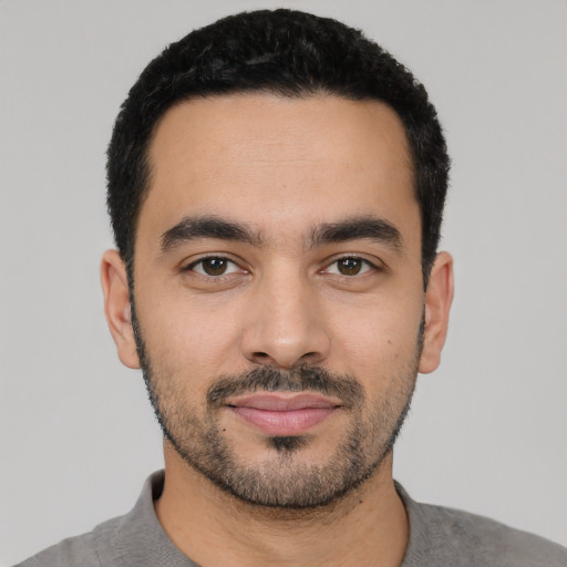 Joyful latino young-adult male with short  black hair and brown eyes