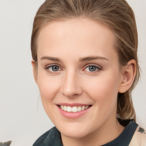 Joyful white young-adult female with medium  brown hair and grey eyes