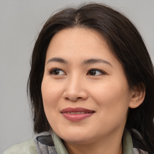 Joyful asian young-adult female with medium  brown hair and brown eyes