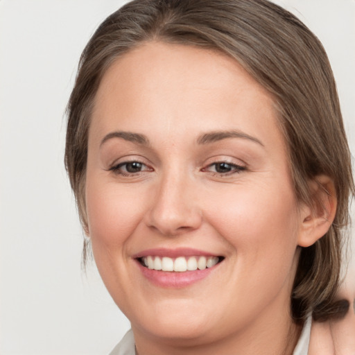 Joyful white young-adult female with medium  brown hair and grey eyes