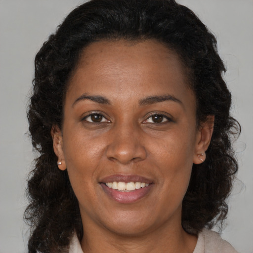 Joyful black adult female with long  brown hair and brown eyes