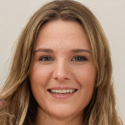 Joyful white young-adult female with long  brown hair and green eyes