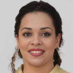 Joyful latino young-adult female with medium  brown hair and brown eyes