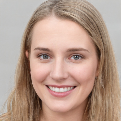 Joyful white young-adult female with long  brown hair and grey eyes