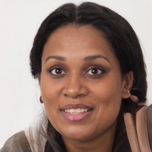 Joyful black adult female with medium  brown hair and brown eyes