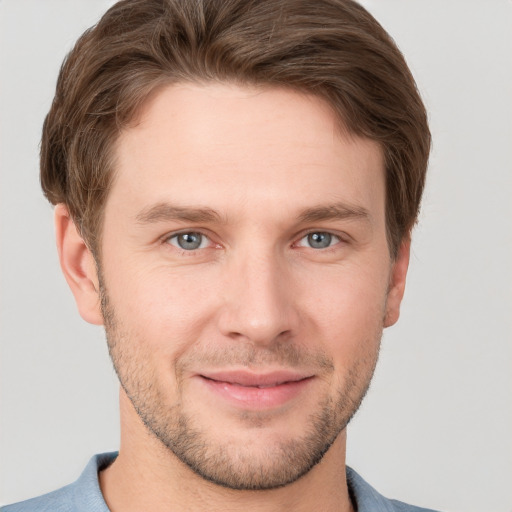 Joyful white young-adult male with short  brown hair and grey eyes