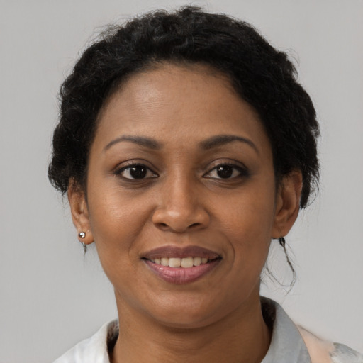 Joyful black adult female with short  brown hair and brown eyes
