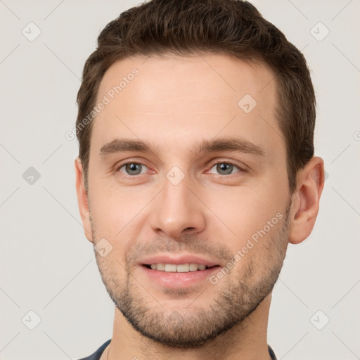 Joyful white young-adult male with short  brown hair and grey eyes