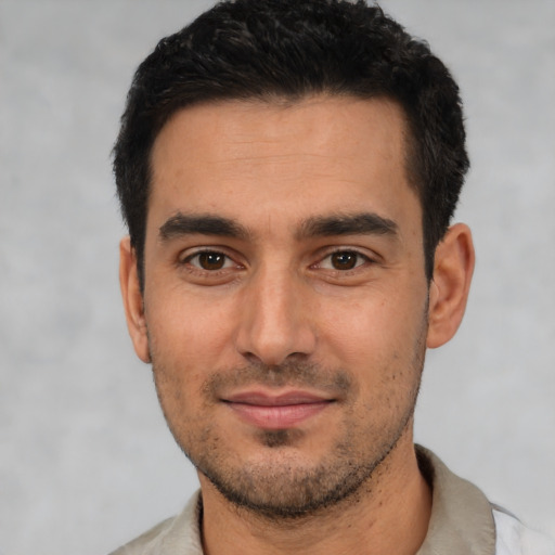 Joyful white young-adult male with short  black hair and brown eyes