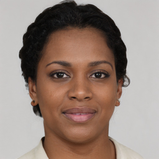 Joyful black young-adult female with short  black hair and brown eyes