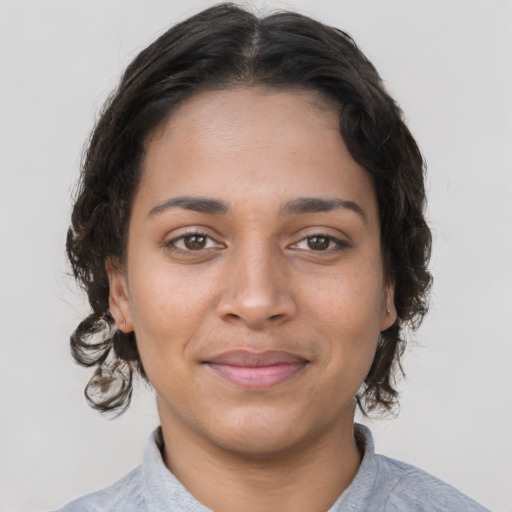 Joyful latino young-adult female with medium  brown hair and brown eyes