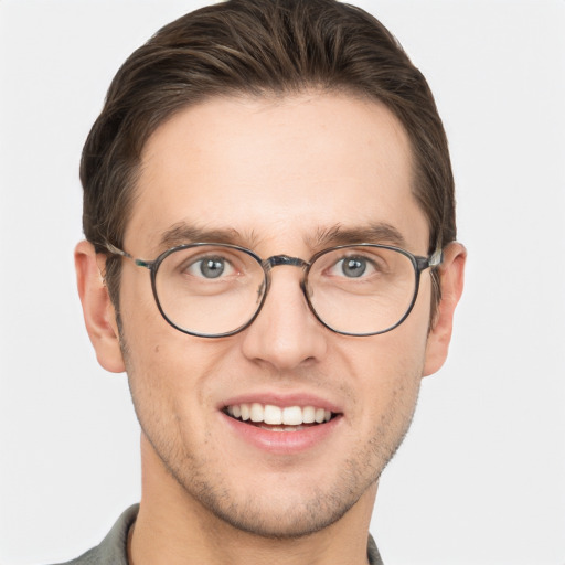 Joyful white young-adult male with short  brown hair and grey eyes