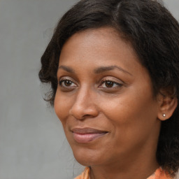 Joyful black adult female with long  brown hair and brown eyes