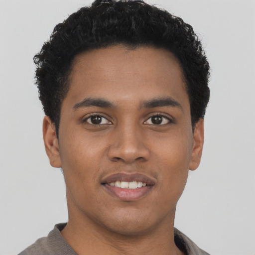 Joyful black young-adult male with short  black hair and brown eyes
