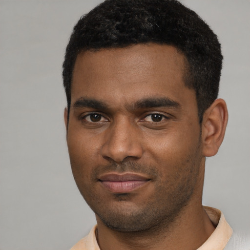 Joyful black young-adult male with short  brown hair and brown eyes