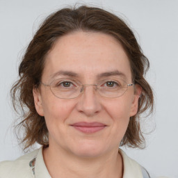 Joyful white adult female with medium  brown hair and grey eyes