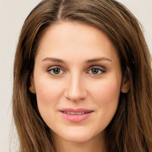 Joyful white young-adult female with long  brown hair and green eyes