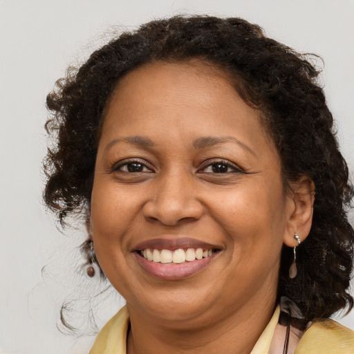Joyful black adult female with medium  brown hair and brown eyes