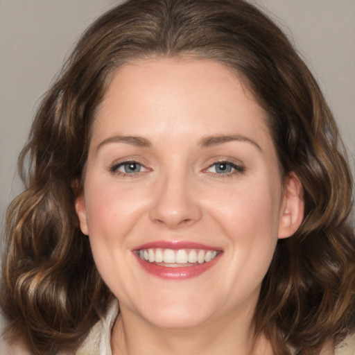 Joyful white young-adult female with medium  brown hair and grey eyes