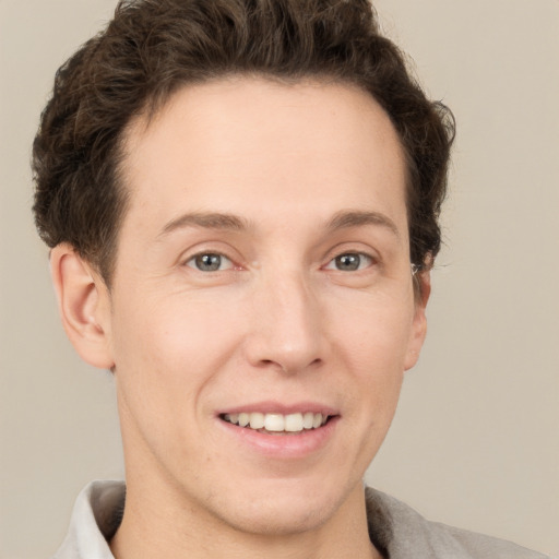 Joyful white adult male with short  brown hair and grey eyes