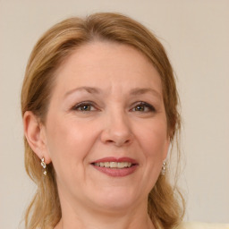 Joyful white adult female with medium  brown hair and blue eyes