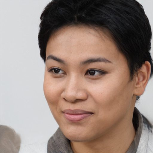 Joyful asian young-adult female with short  black hair and brown eyes