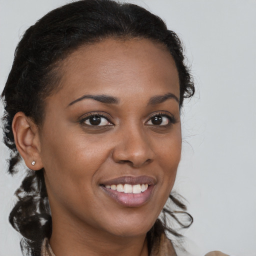 Joyful black young-adult female with long  brown hair and brown eyes