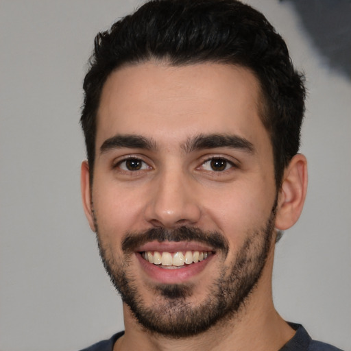 Joyful white young-adult male with short  black hair and brown eyes