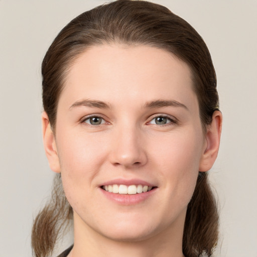 Joyful white young-adult female with long  brown hair and grey eyes