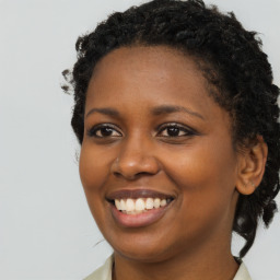 Joyful black young-adult female with long  brown hair and brown eyes