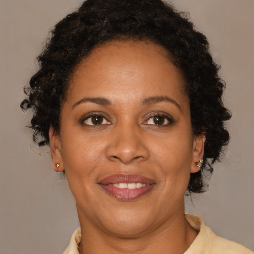 Joyful black adult female with short  brown hair and brown eyes